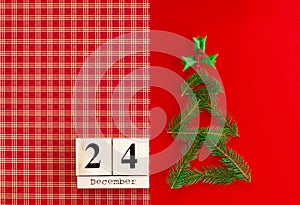 Wooden calendar with 24 december date on the red background. New year and Christmas concept, holiday decorations