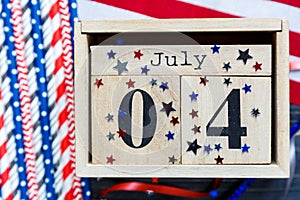 Wooden calendar 4th of July day of American independence, decorations,  flag, candles, straws. USA holiday decorations