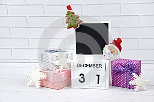 Wooden calendar with the date December 31st with holiday decorations.