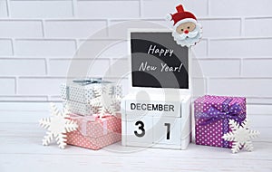 Wooden calendar with the date December 31st with holiday decorations.