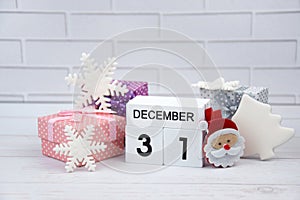 Wooden calendar with the date December 31st with holiday decorations.