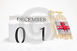 Wooden calendar for December, 1 st day of the winter month. The symbols of winter are snow and sleigh. Concept of holidays,