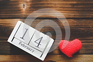 Wooden Calendar On February 14, red heart were placed side by side with old wooden background.