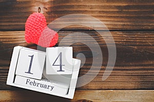 Wooden Calendar On February 14, red heart were placed side by side with old wooden background.