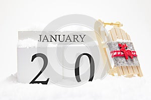 Wooden calendar for January, 20 th day of the winter month. The symbols of winter are snow and sleigh. Concept of holidays,
