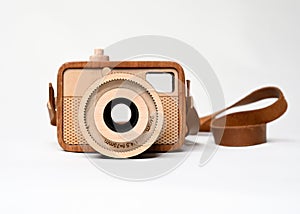 Wooden camera toy with strap on white background