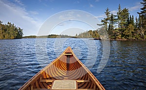 Wooden canoe on a blue Boundary Waters lake with islands on an autumn morning