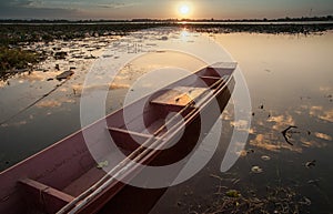 Wooden canoe on lake sunset background fishing boats Asia