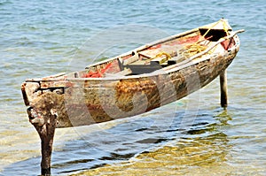 Wooden canoe moored on posts