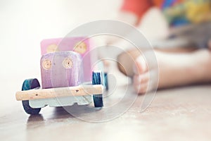 Wooden car toy  in child`s hand.