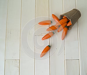 A wooden carrot is a toy.Children`s toy of orange color.