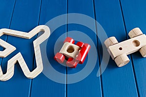 Wooden cars and plane on classic blue background. Set of colorful toys for games in kindergarten, preschool kids. Close up,