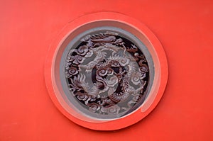 Wooden Carved dragon in circle on red background in Chinese Buddhism Temple in Lumbini, Nepal