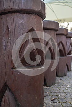 Wooden carved posts on the street, old-style log fence