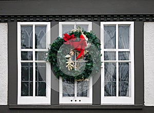 Wooden casement window decorated with Christmas wreath photo