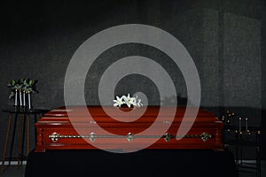 Casket with white lilies and burning candles in funeral home photo