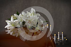 Wooden casket with white lilies in funeral home photo