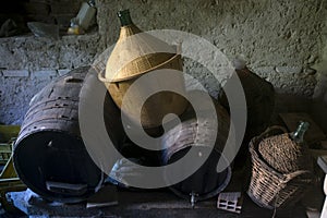 Wooden casks and demijohn in an old cellar