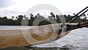 The wooden catamaran float of traditional dhow fishing boat floating be the river at Pemba Island, Zanzibar, Tanzania.