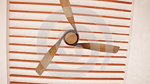 Wooden ceiling fan gracefully spinning in a circular motion. The elegant motion