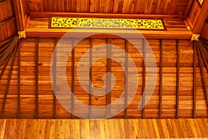 Wooden ceiling with golden elements in the Buddhist temple Brahma Vihara Arama, Bali, Indonesia. Balinese Wooden Ceiling