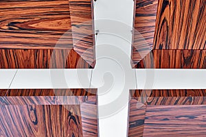 Wooden ceiling panels. Rosewood fineline veneer ceiling panels in the modern office