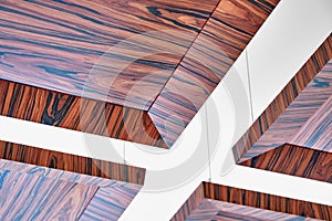 Wooden ceiling panels. Rosewood fineline veneer ceiling panels in the modern office