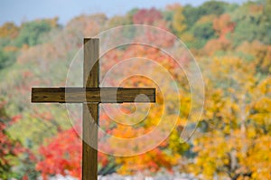 Wooden cemetery cross and fall color trees