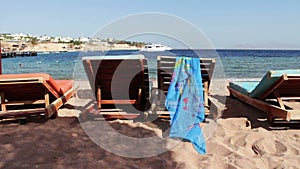 Wooden chair at the beach of background of blue sea and white yacht floats