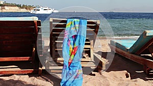 Wooden chair at the beach of background of blue sea and white yacht floats