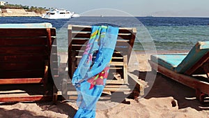 Wooden chair at the beach of background of blue sea and white yacht floats