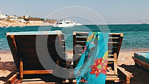 Wooden chair at the beach of background of blue sea and white yacht floats