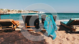 Wooden chair at the beach of background of blue sea and white yacht floats