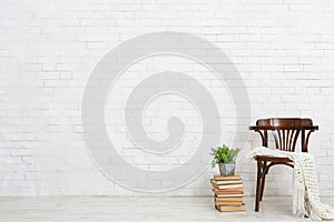 Wooden chair, books and plant on the floor