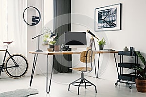 Wooden chair at desk with desktop computer in bright workspace i