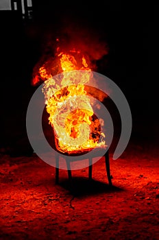 Wooden chair is on fire. Incineration of furniture. Conceptual p