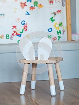 wooden chair for kids with a white board and magnets in the background