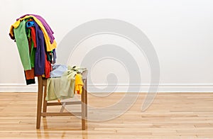 Wooden chair with messy clothes on it photo