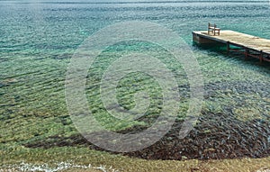 Wooden chair on pleasure pier on Greek Dodecanese Telendos island