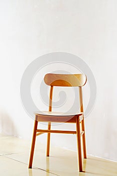 Wooden chair in retro style on a white wall background. Vertical photo