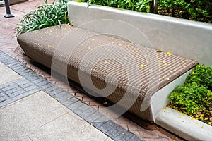 Wooden chair or wood bench with concrete structure along a walkway