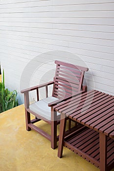 Wooden chair on yellow cement floor with mortar wall