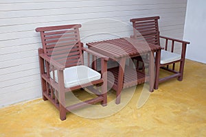 Wooden chair on yellow cement floor with mortar wall