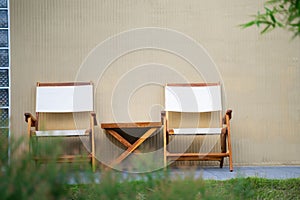 Wooden chairs with backrests paired with a small wooden table. In the garden to relax on holidays