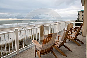 Wooden chairs on balcony by the beach photo