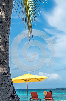 Wooden chairs and beach umbrella on a beautiful tropical beach