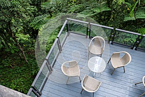 Wooden chairs with glass table on patio in garden