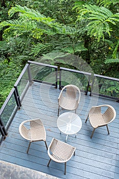 Wooden chairs with glass table on patio in garden