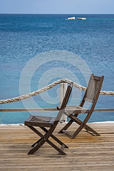 Wooden chairs on a restaurant deck on seaside in Greece