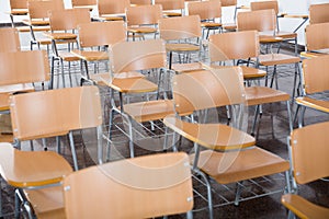Wooden chairs in rows in classroom of school interior, no people